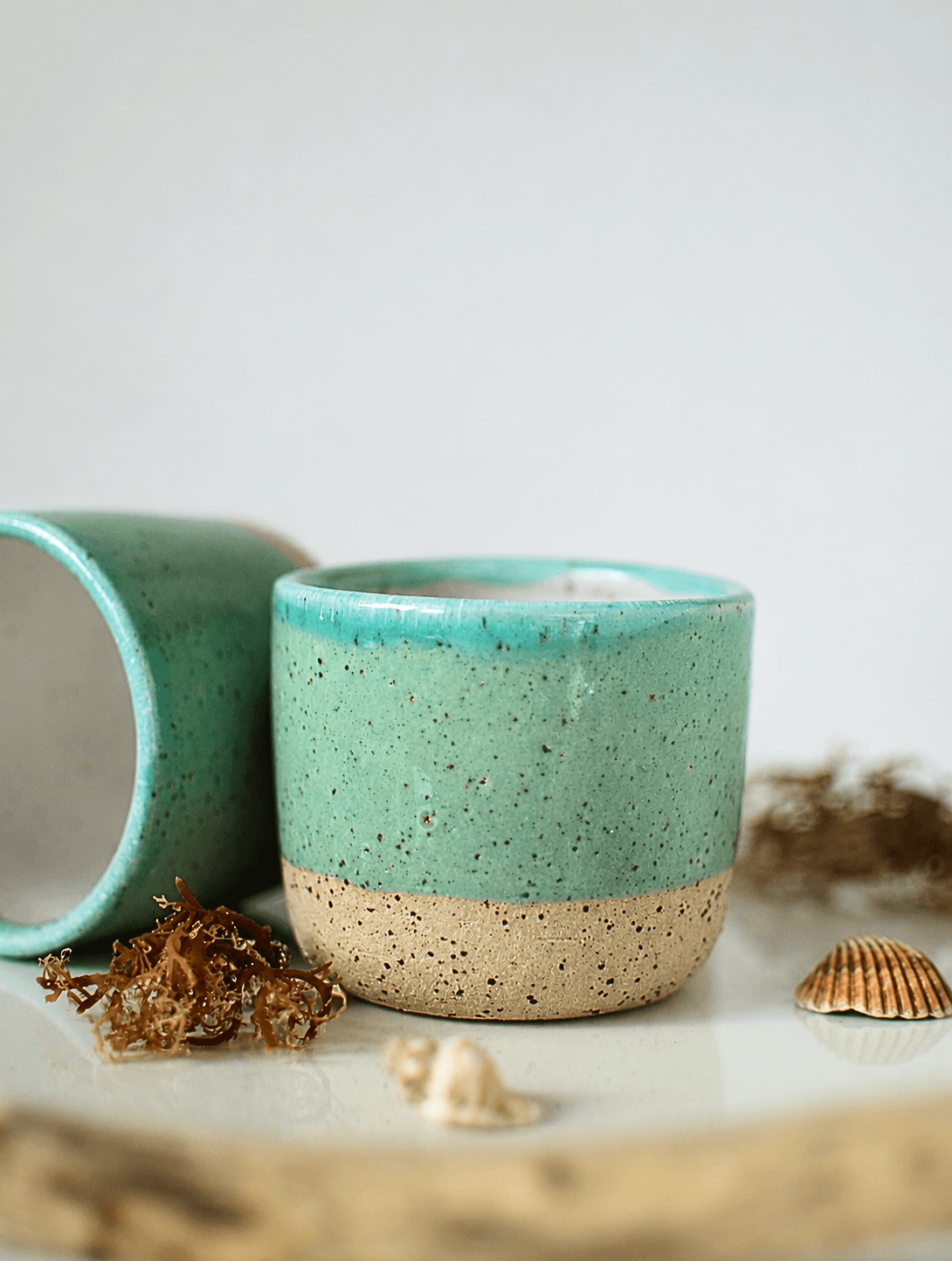 Handmade stoneware cups with turquoise glaze and speckled clay base, coastal styling with seashells β Maguelone collection, Studio Lippi Ceramics in Dublin