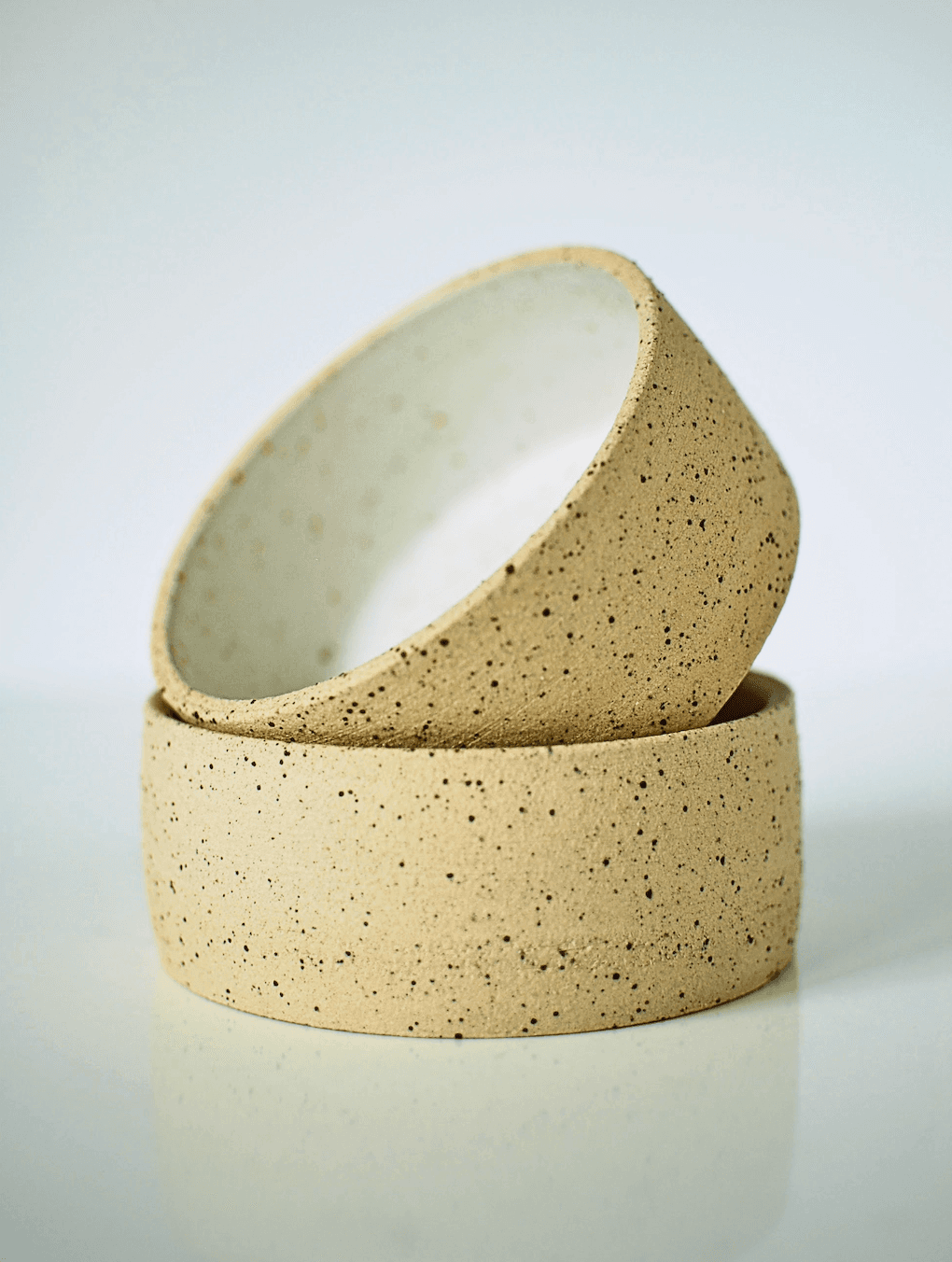 Two handmade stoneware bowls stacked, unglazed speckled clay exterior with white glazed interior β Sable collection, wheel-thrown ceramics made in Dublin, Ireland